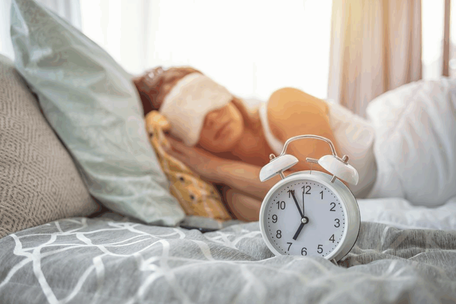 Woman sleeping peacefully, ready to wake up with alarm clock
