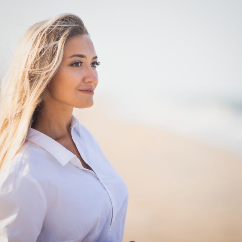 woman with blond hair overlooking the ocean