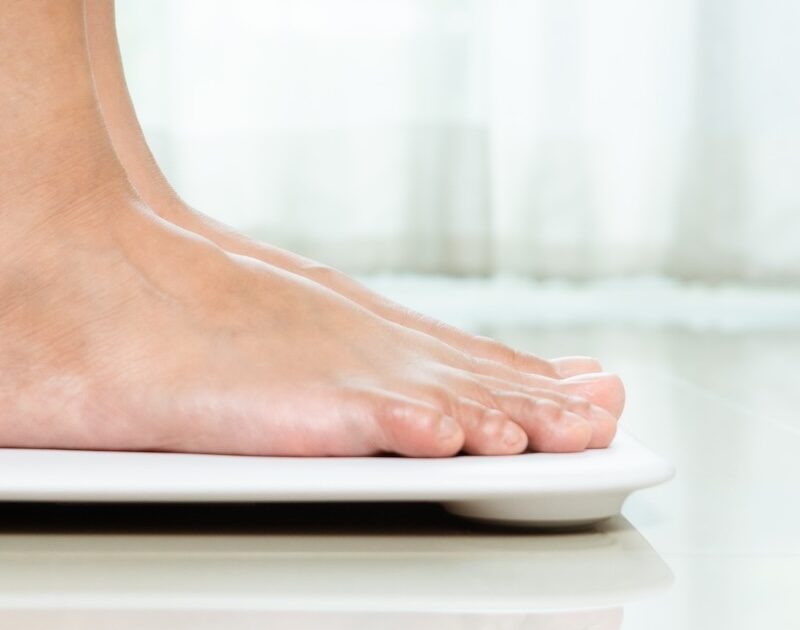 Female standing on a scale in her home