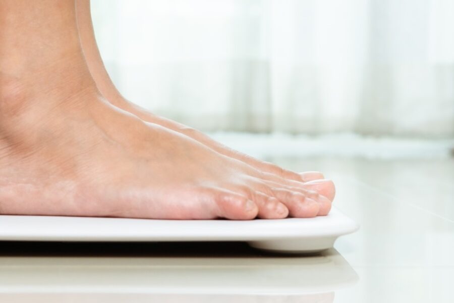 Female standing on a scale in her home