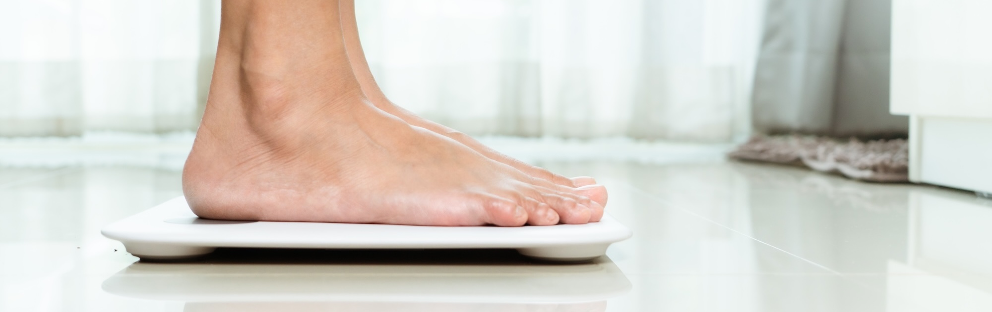 Female standing on a scale in her home