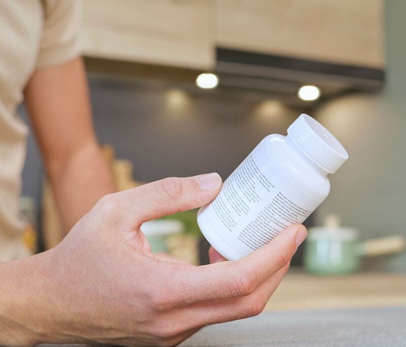 man reading the label on a bottle of hormone pellets
