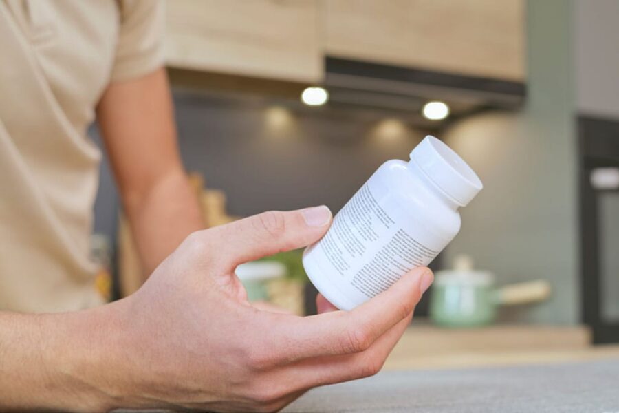 man reading the label on a bottle of hormone pellets
