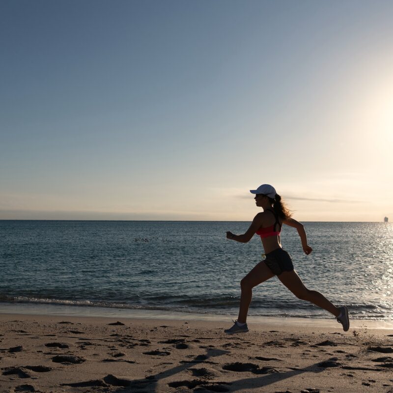 woman feeling strong running along the beach