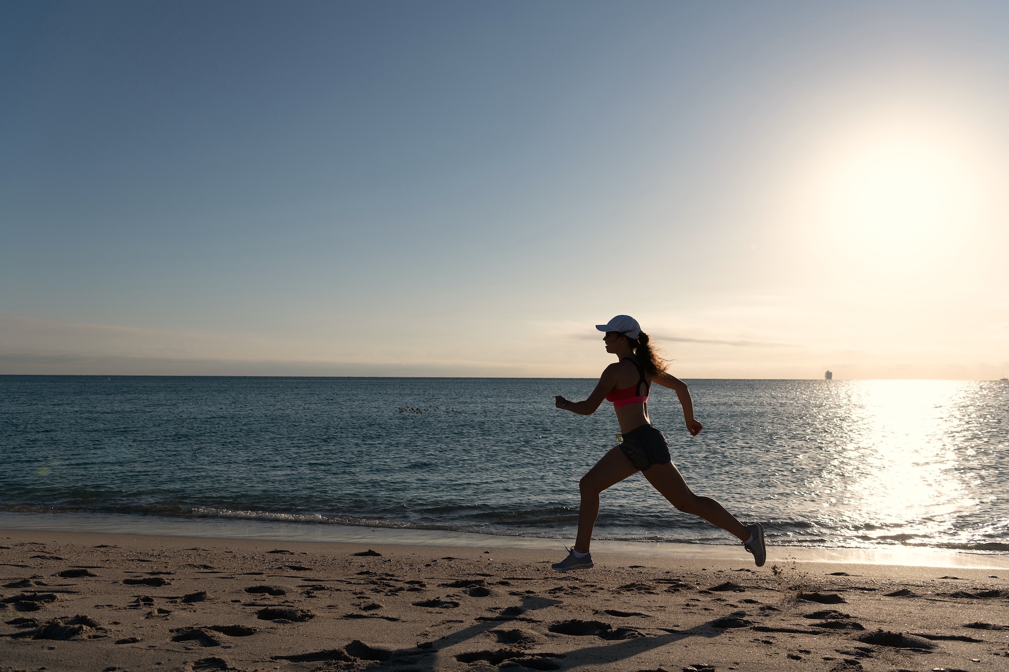 woman feeling strong running along the beach